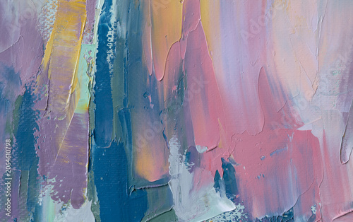Mixing paint with a palette knife in an oil painting with colorful fragments on a canvas