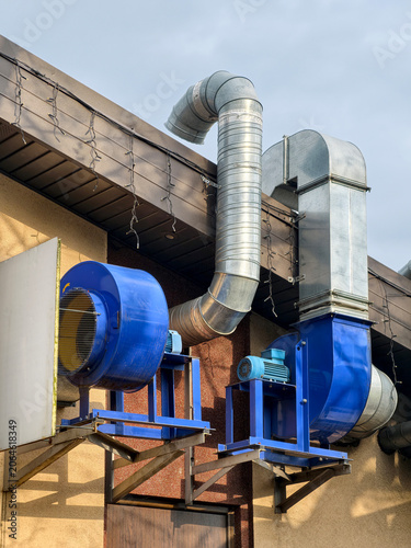 Industrial building rooftop featuring exterior ventilation fan with electric motor for efficient air exhaust