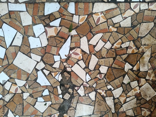 Fotografie Colorful broken ceramic tile mosaic floor with irregular shards in brown, orange