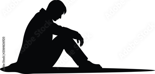 Tableau sur toile Side view silhouette of a depressed man sitting on ground with head down for lon
