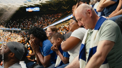 Slika na platnu Disappointed soccer supporters reacting to missed chance during tense football match, filled with hope and tension in the stadium stands, Worried fans speechless and holding breath, last chance