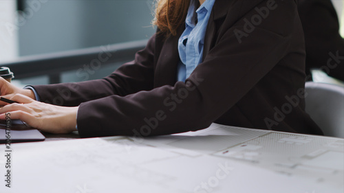 Photos Interior designer studying architectural blueprints in office to translate accurate measurements of physical spaces in order to create new floor plan