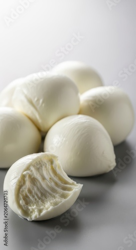 Fresh milky white mozzarella cheese balls resting on a neutral surface, showcasing the soft texture and bright color ready for cooking or slicing, table, high quality, traditional