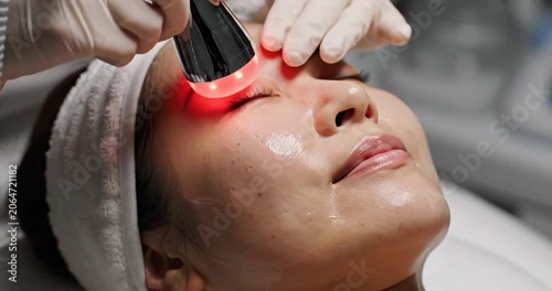 Woman receiving professional red light facial rejuvenation treatment