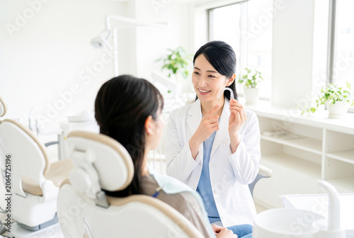 マウスピース矯正を説明する日本人女性歯科医師と説明を受ける女性患者の歯科カウンセリング風景