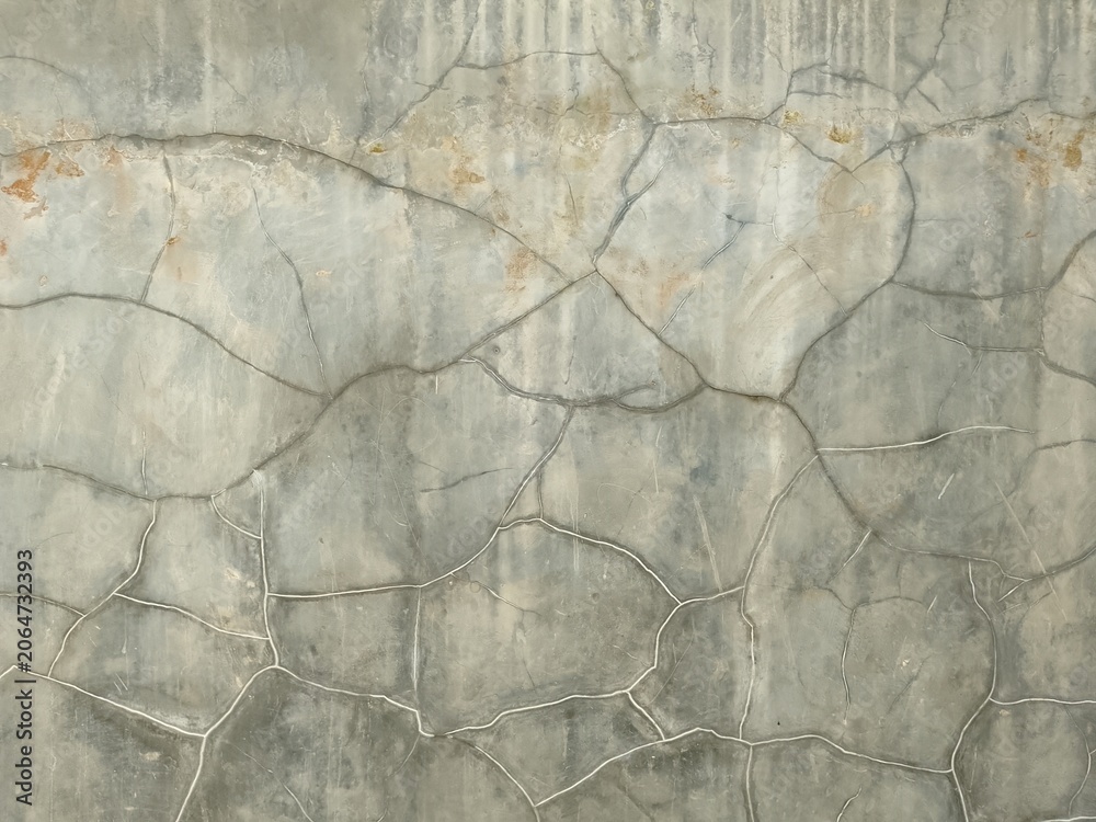 Fototapeta premium weathered grey concrete wall with multiple hairline cracks