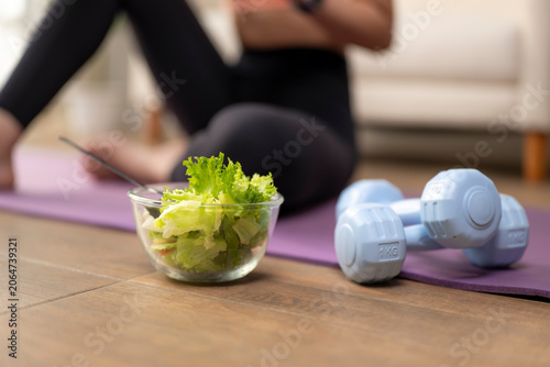 Woman combining healthy eating with home fitness exercise