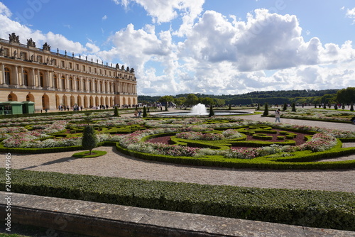 Fotografie Formal French Garden Parterre with Fountain and Palace of Versailles Facade, Fra
