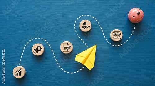 Strategic Business Development Journey Visualized with Paper Plane and Icons on Blue Surface