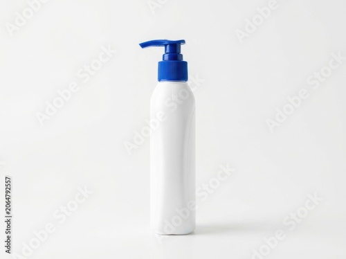White plastic cosmetic bottle with a blue pump dispenser isolated on white background