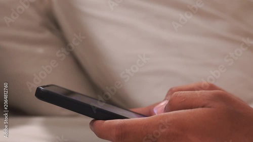 Man in bed at night using a mobile phone. A close-up shot of someone dealing with insomnia. Digital addiction, mental health, technology overuse.