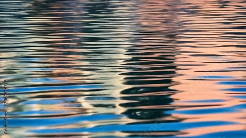 Abstract Water Surface with Ripples and Colorful Reflections.