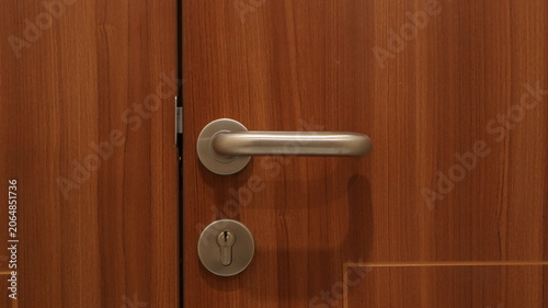 Close-up of a modern wooden door with a metallic handle and keyhole. The image highlights interior architecture, home security, privacy, and access control concepts. 