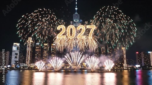 Colorful fireworks display over a city waterfront at night.