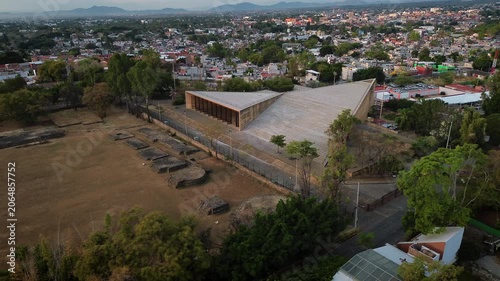 Aerial drone slowly approaches the Teopanzolco Cultural Center in Cuernavaca, a modern architectural building standing alongside the adjacent archaeological zone