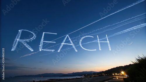 Inspirational Sky Writing of the Word Reach Over Serene Coastal Landscape at Dusk with Beautiful Gradient Colors