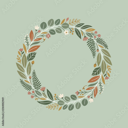 A decorative circular wreath made of various green autumn leaves