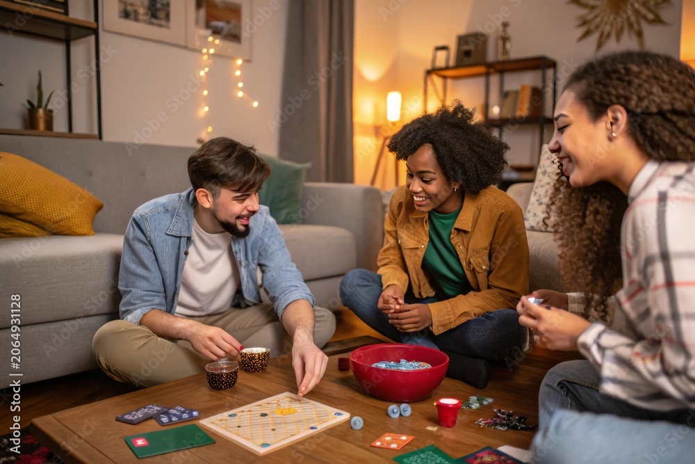 Fototapeta premium Three friends enjoy board game night together