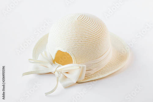 Tableau sur toile A beige, straw women's hat with a large bow on white background