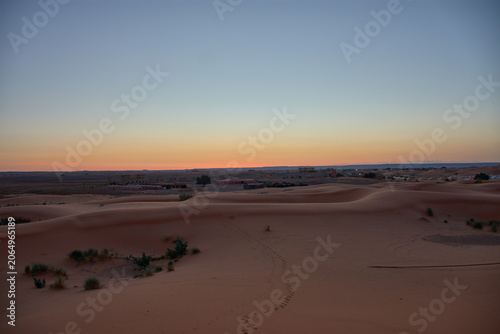 A stunning desert landscape reveals undulating textures in the twilight light of Merzouga, Morocco.