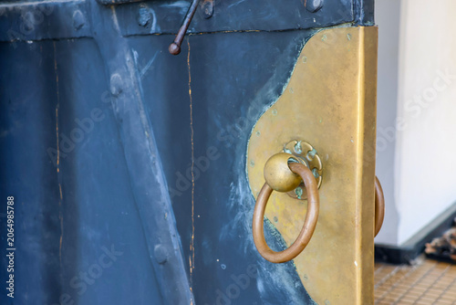 Obraz na plátně Old brass door handle gleams against dark wood