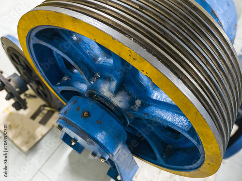 Close-up photo of industrial pulley and bearing assembly with belt grooves. Perfect for engineering, mechanical, and industrial design themes.