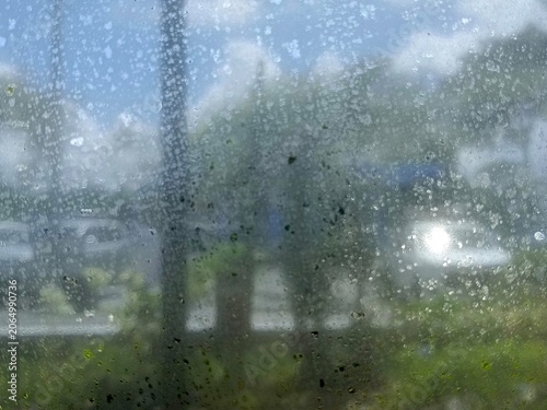 Dirty window glass texture with water stains and green algae spots blur city background outdoor daytime