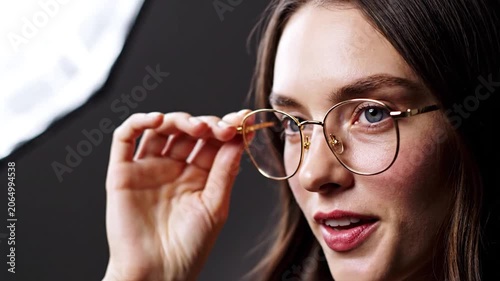 Young woman wearing gold round blue light blocking glasses in studio