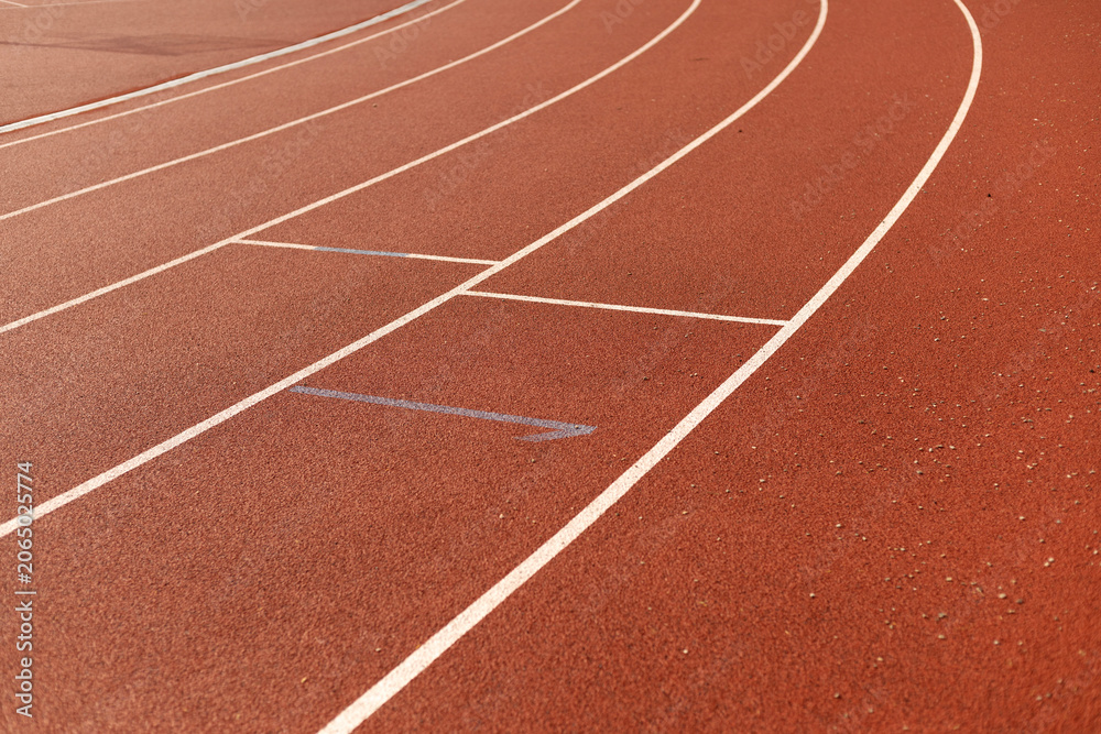 Fototapeta premium Red athletic running track with white lane markings