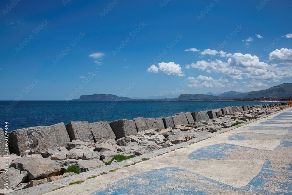 Fototapeta premium Palermo, Italy 05 13 2026: wave breaker and island at the coast of Palermo in Sicily