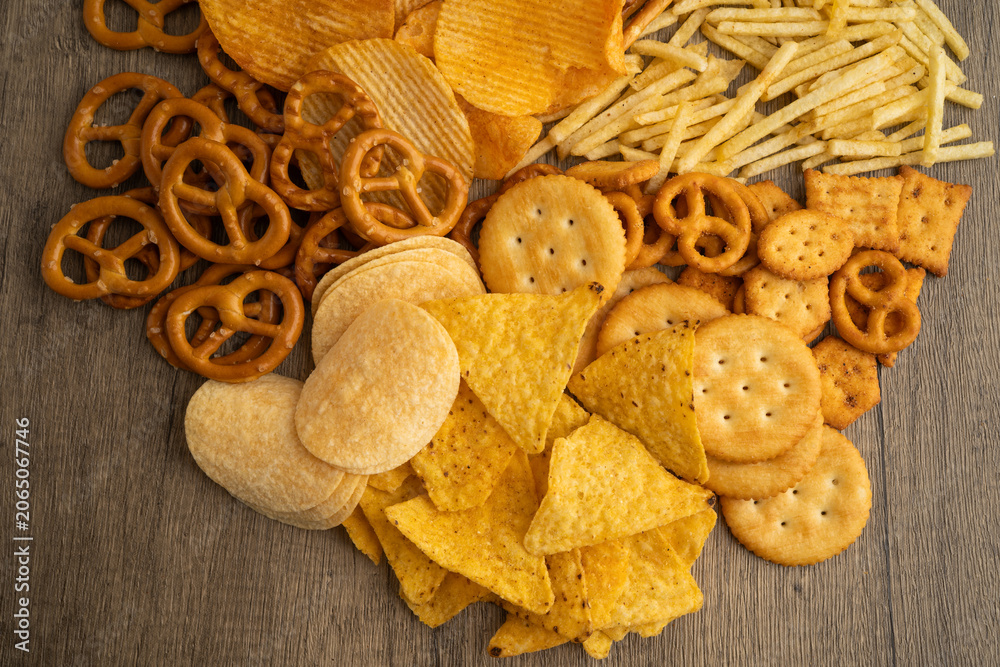 Fototapeta premium Mix of variety snack chips pretzel and cracker, junk crunchy food.