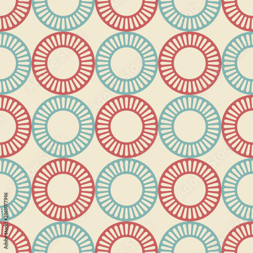 Seamless retro geometric vector pattern with repeating circular ring motifs in red and teal on a beige background. Mid-century modern style wallpaper, fabric, wrapping paper or textile design.