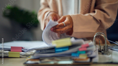 Konstfotografi Hands flip through papers with focused intent