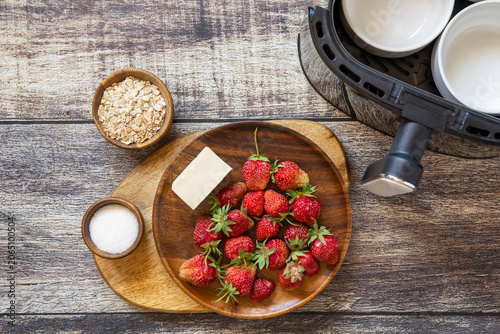 Ingredients for cooking homemade english crumble cake with strawberry in kitchen gadget modern air fryer. Lifestyle trendy of new cooking.
