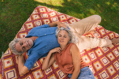 Senior couple relaxing on picnic blanket in garden