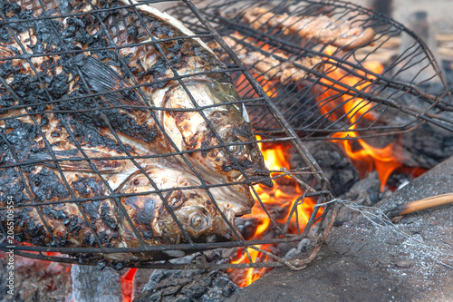 фотографія Preparing and grilling Masgouf over an open fire in the southern marshes of Iraq, fish cooked over an open fire is the most popular food in Iraq, Middle East