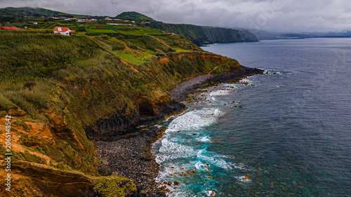 Scenic rocky coast and steep green cliffs of Ribeira Grande shoreline