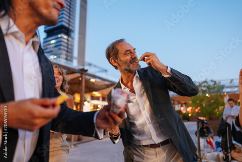 People sharing snacks at outdoor social gathering