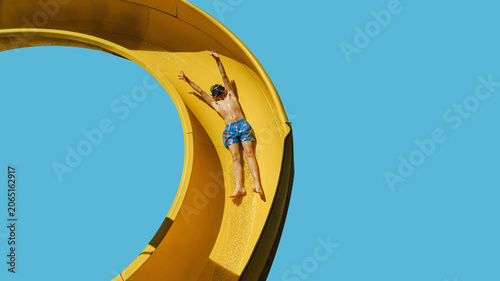  Off on vacation. A child is sliding down the water slide, is ready for her holiday. Dreaming of a vacation concept.