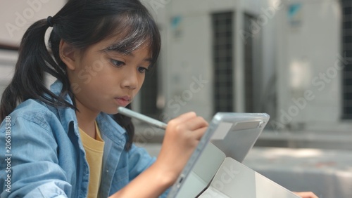 Clever Asian youth learner using smartphone device while sitting on school library floor. Smart student browsing digital online data network to search modern tech solutions.