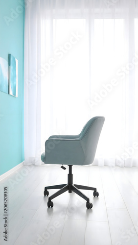 Creative design studio with a light gray ergonomic office chair featuring a soft lumbar cushion, set in an airy modern workspace. 
