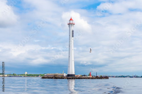 A lighthouse against a blue sky with clouds in Kronstadt, Saint Petersburg, Russia