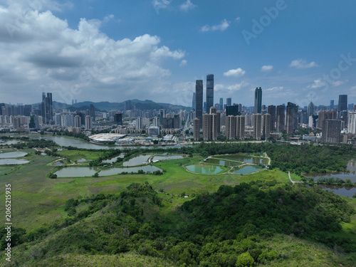Aerial view of rural green fields with fish ponds on Hong Kong and the skylines of Shenzhen