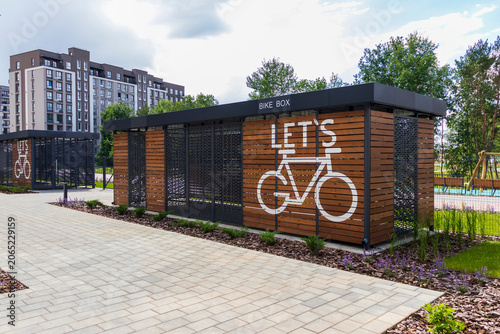 Modern wooden bike box storage facility in a contemporary residential neighborhood. Urban
