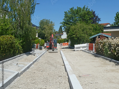 Street maintenance and repaved work on urban environment and an  excavator with shovel on site