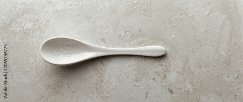 White ceramic spoon on a textured surface