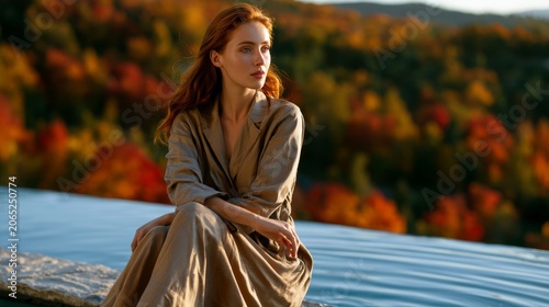Young woman with red hair contemplating the autumn landscape by the water