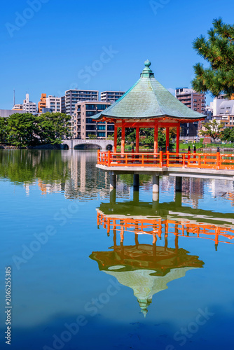 Iconic hexagonal red pavilion of Ohori lake park with Fukuoka city