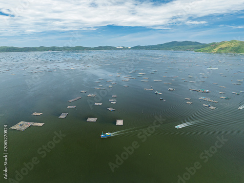 Aerial view of extensive floating aquaculture farms and fishing boats in coastal waters near Song Cau town, Dak Lak province, Vietnam.