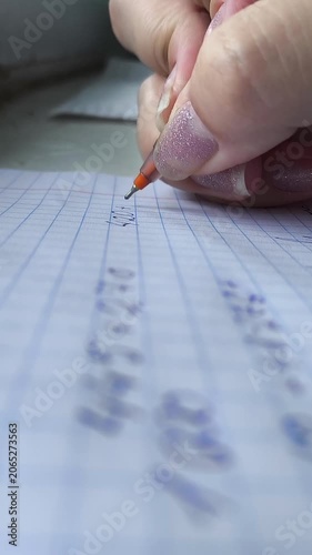 The hand uses a pen to write down the numbers on the paper. An accountant draws up an annual report. Finance, economy, crisis. Wages and expenses